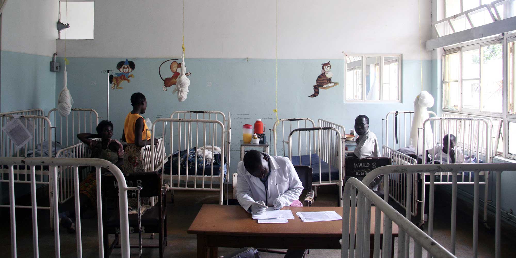 Photo: A health worker sits at a desk in a pediatric hospital room in Zambia. When children fall ill with diarrheal disease, the hospital bills can add up – and the indirect costs, too. PATH/David Jacobs