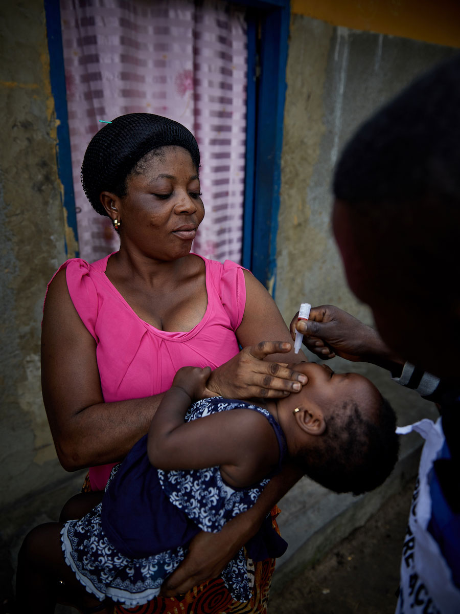 Community health worker Tangomo Tansia vaccinates one-year old Ruth Make, as her mother Mbase Make looks on in Bandundu. “The families warmly welcome us and thank us for keeping their children safe from diseases,” says Tansia © Hugh Cunningham