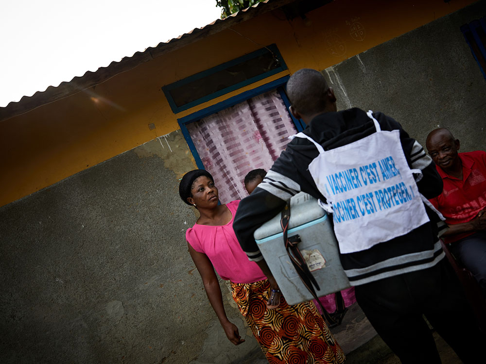 Community health worker Tangomo Tansia vaccinates one-year old Ruth Make, as her mother Mbase Make looks on in Bandundu. “The families warmly welcome us and thank us for keeping their children safe from diseases,” says Tansia © Hugh Cunningham