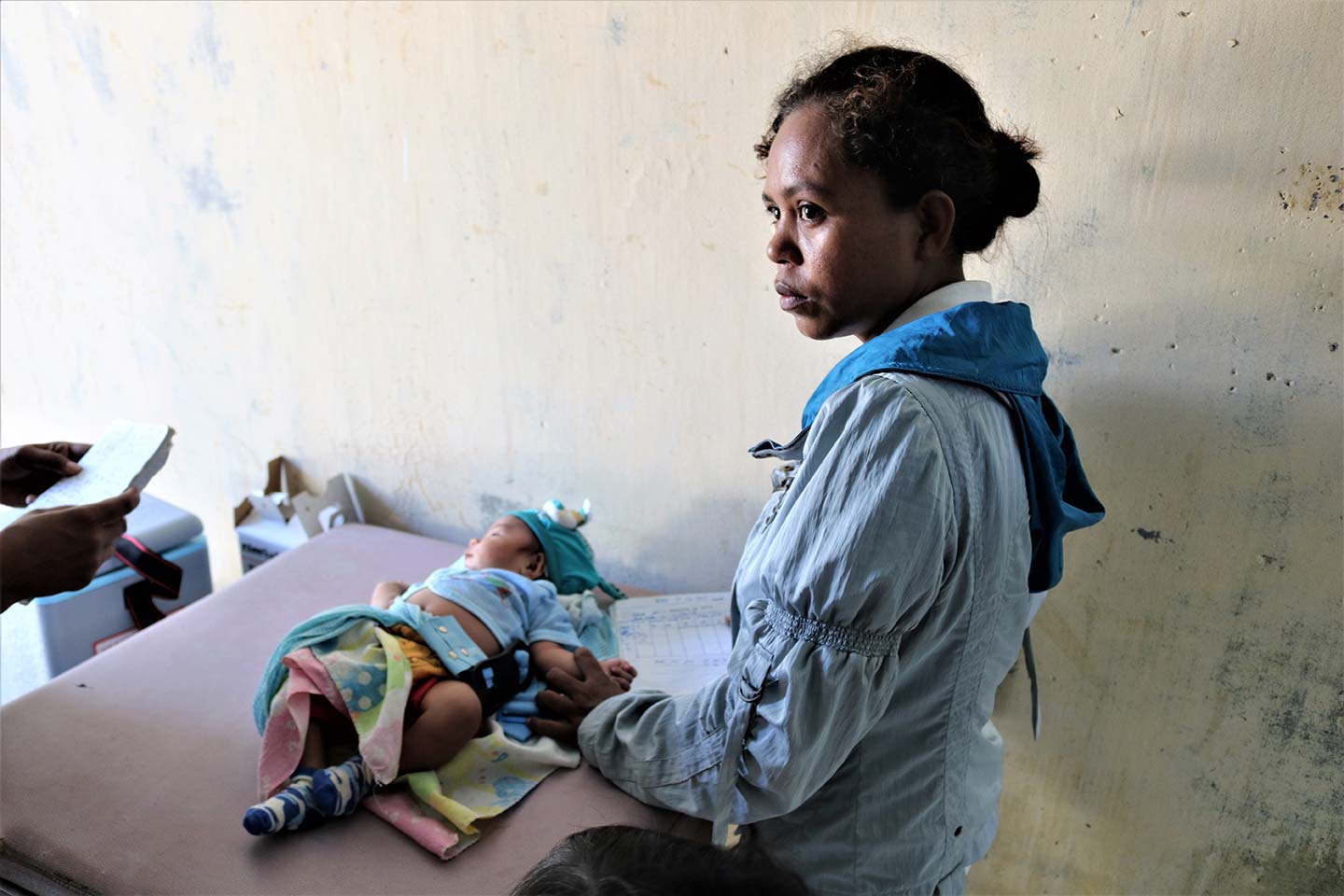 A mother waits for her child to be vaccinated at the Comoro Community Health Centre in Dili. © UNICEF Timor-Leste/Galvin