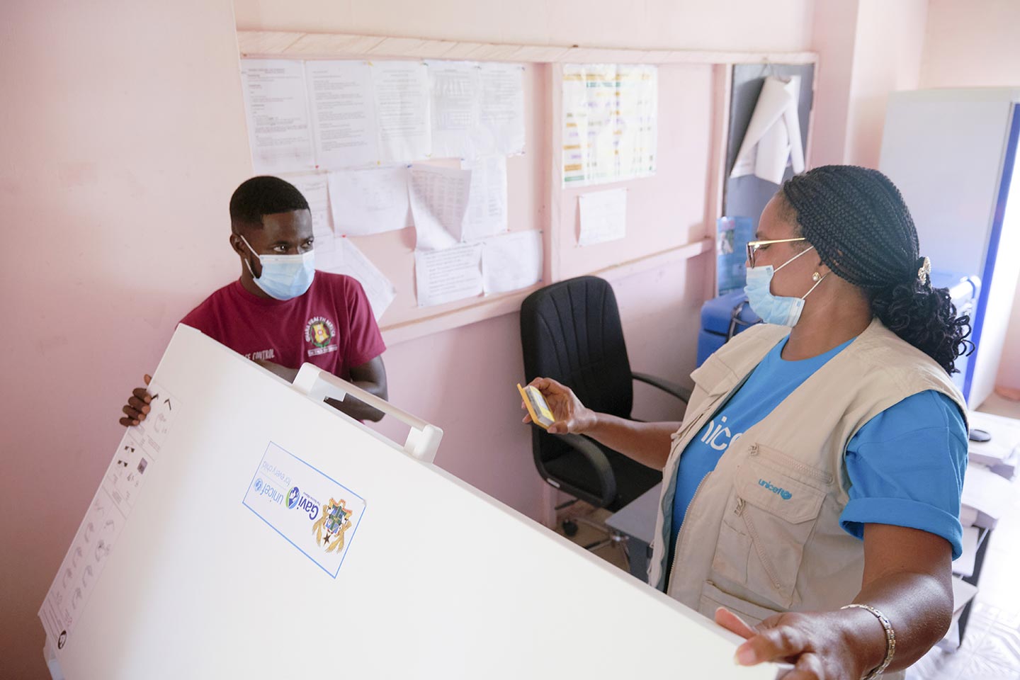 UNICEF Communication for Development Officer, Charity Nikoi checks on cold chain equipment and vaccine storage at the Pepease Health Centre in the Kwahu East District of the Eastern Region on 8 October 2020. ©UNICEF/ANNANKRA