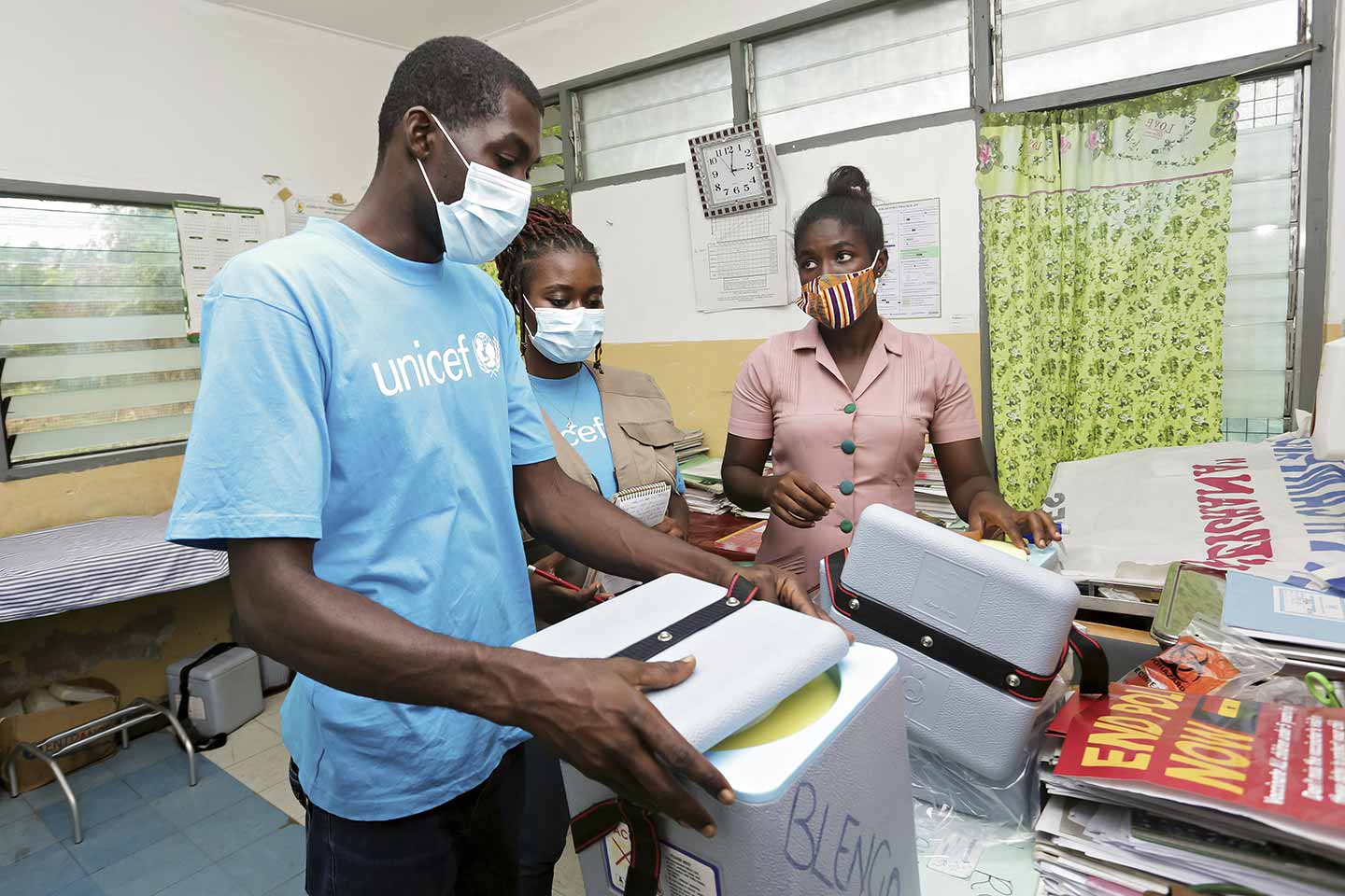 Les fonctionnaires de l'UNICEF Pharoah Semanhyia et Antoinette Gyan inspectent les porte-vaccins dans un centre sanitaire de la région de la Volta avant le début de la première campagne de vaccination, le 9 septembre 2020. ©UNICEF/MILLS