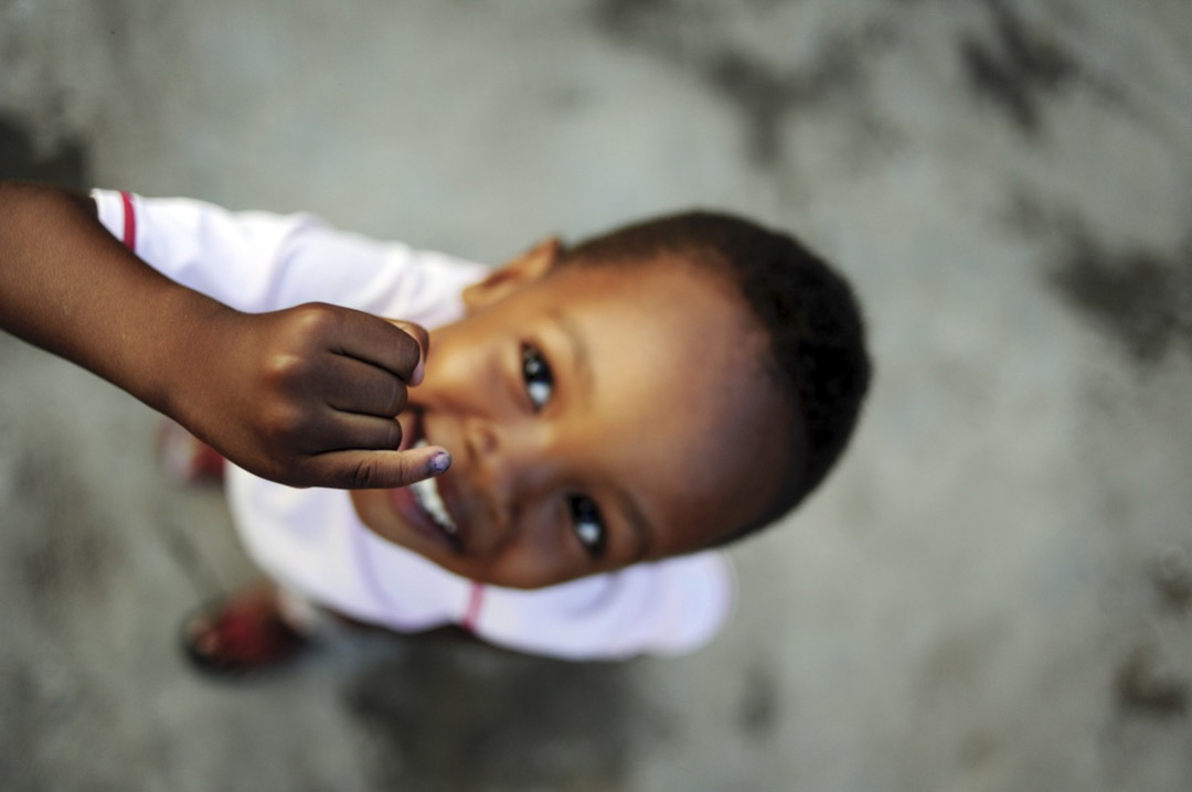 A young boy shows off his marked finger signifying that he has been vaccinated against poliovirus on 7 October 2020. ©UNICEF/BUTA