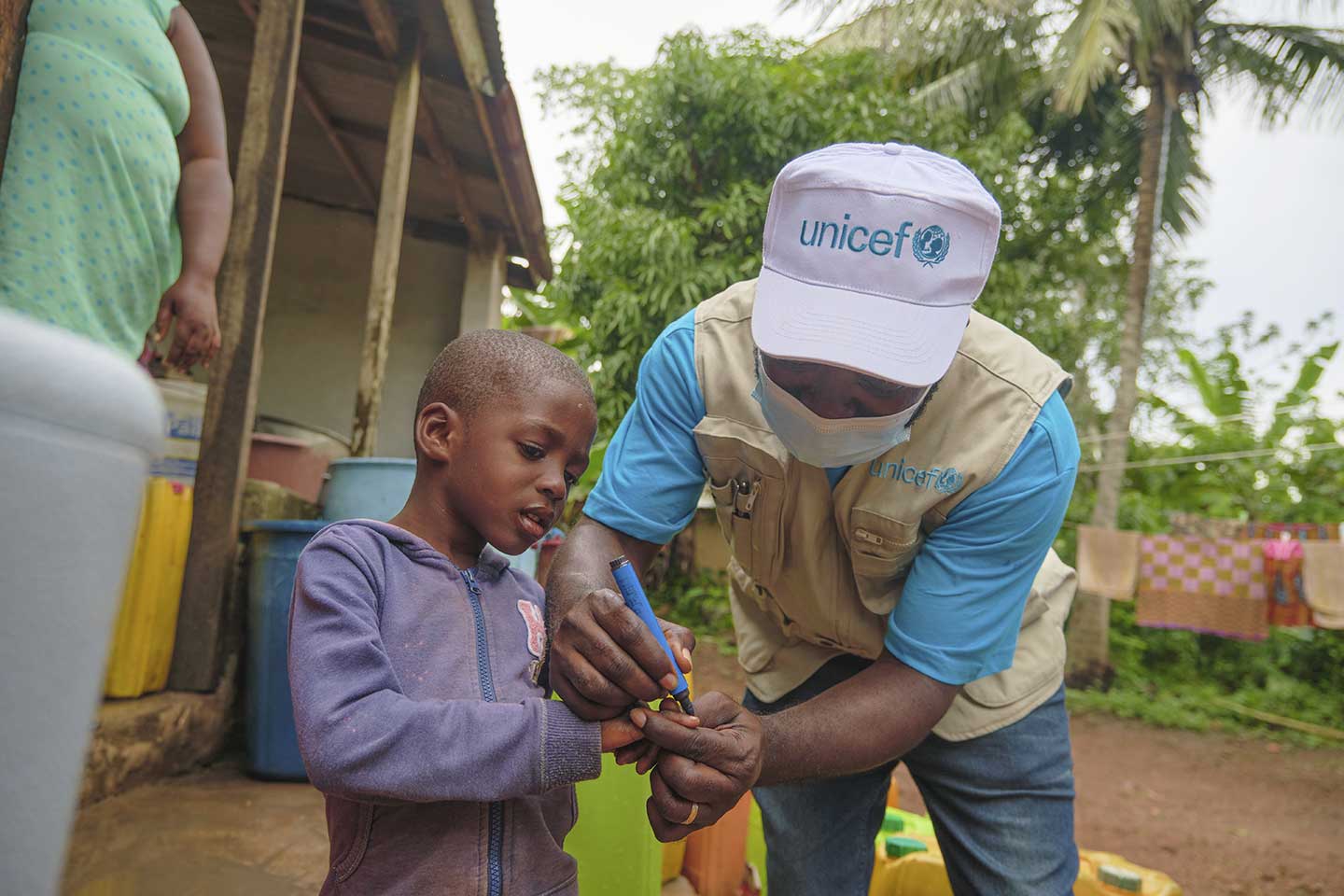 Spécialiste de la santé à l'UNICEF, Felix Osei-Sarpong, marque le doigt d'un enfant qui vient de recevoir le vaccin contre la polio à Kitase, dans la région de l'Est, le 10 octobre 2020. ©UNICEF/ANNANKRA