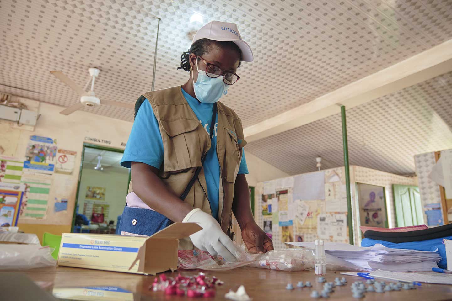 UNICEF Health Officer, Josephine Agborson, inspects vaccine vials at the Berekuso Health Centre in the Eastern Region on 10 October 2020. ©UNICEF/ANNANKRA