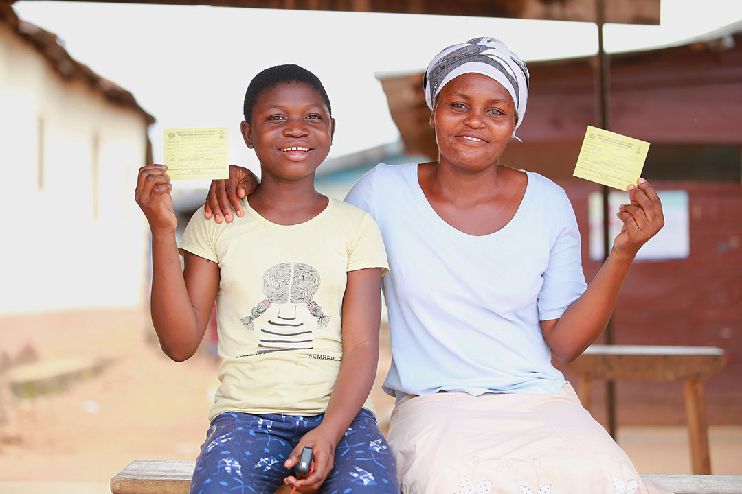 Sandra and Joyce show off their yellow fever vaccination card. ©UNICEF/MILLS