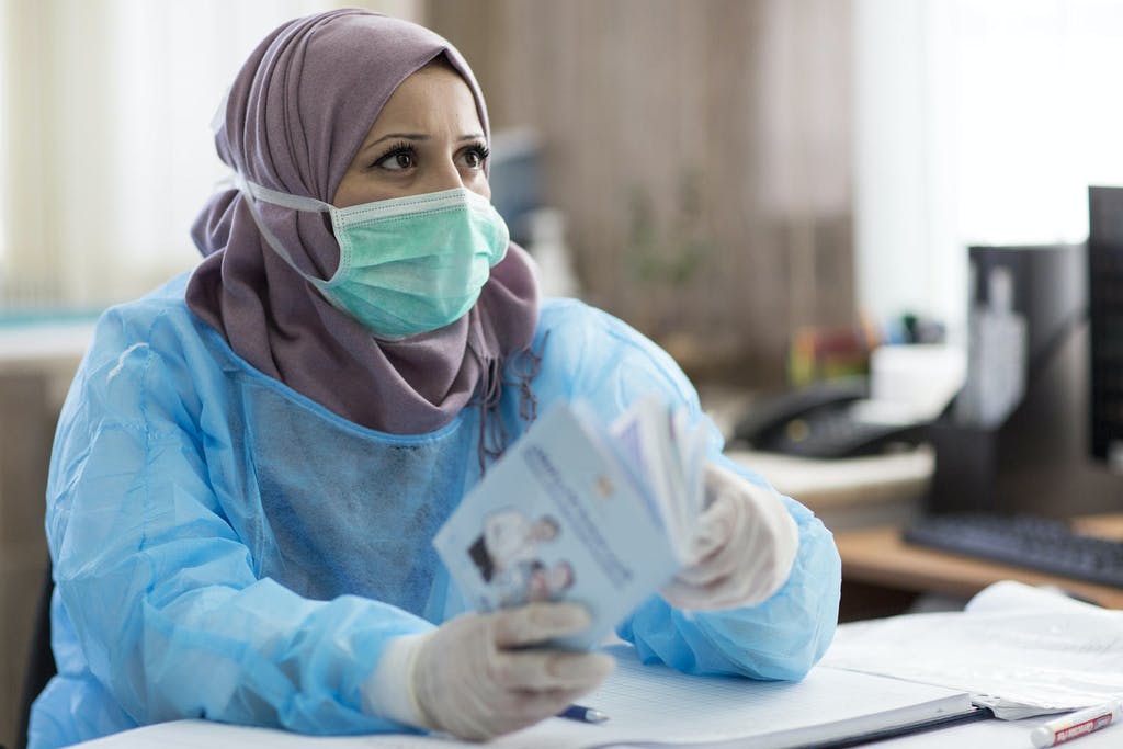 Nurse Hana Barakat holds an immunization booklet at the Ministry of Health clinic in Ramallah, Palestine. Photo: Ahmed Izhiman/UNICEF