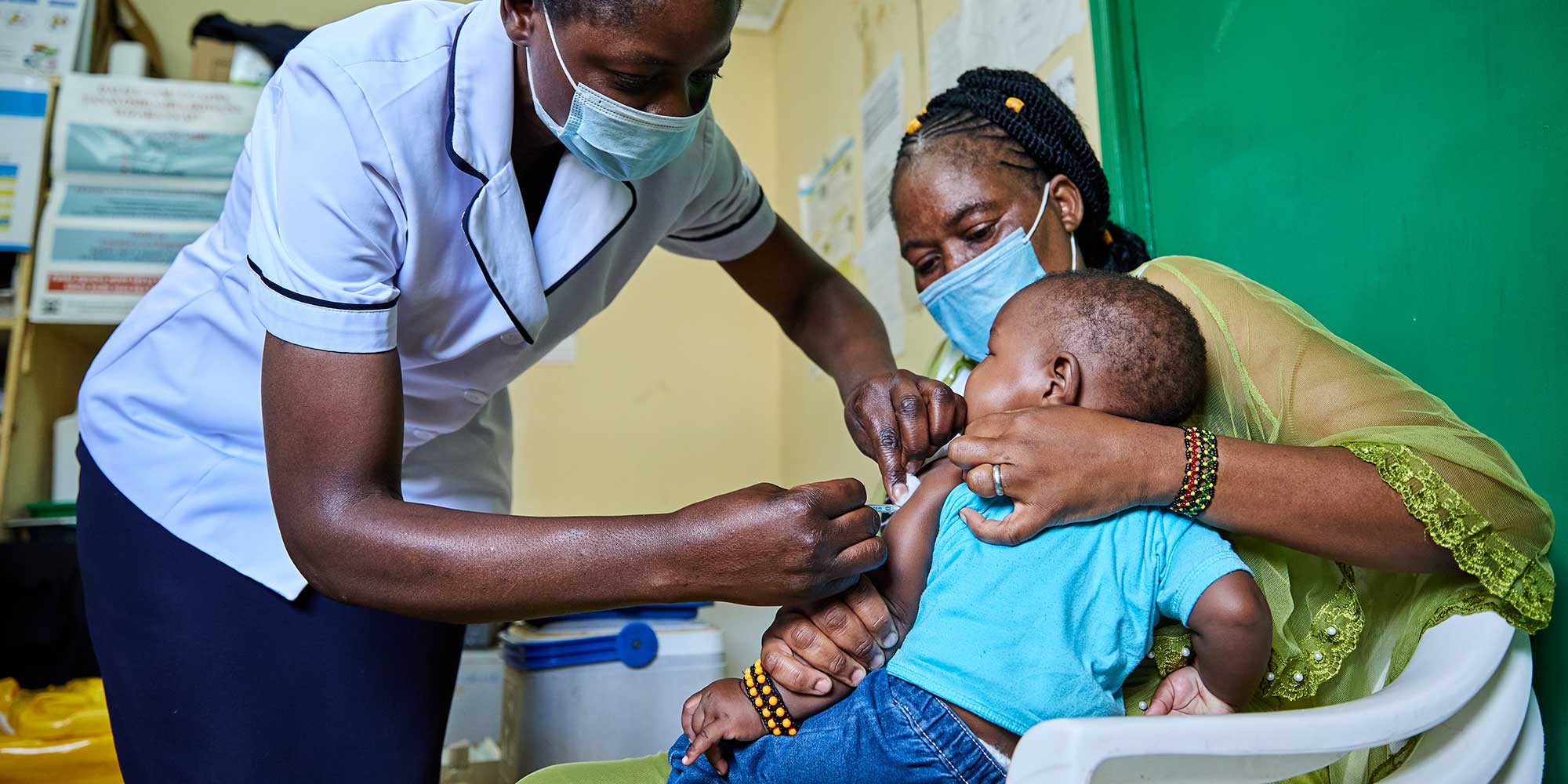 Nurse Janet Wanyama vaccinates 9-month-old Brilliant Hope against malaria while his mother Juliah Machanja watches at the Malava County Hospital Child Welfare Clinic in Kakamega, Kenya. Credit: Gavi/2021/White Rhino Films-Lameck Orina