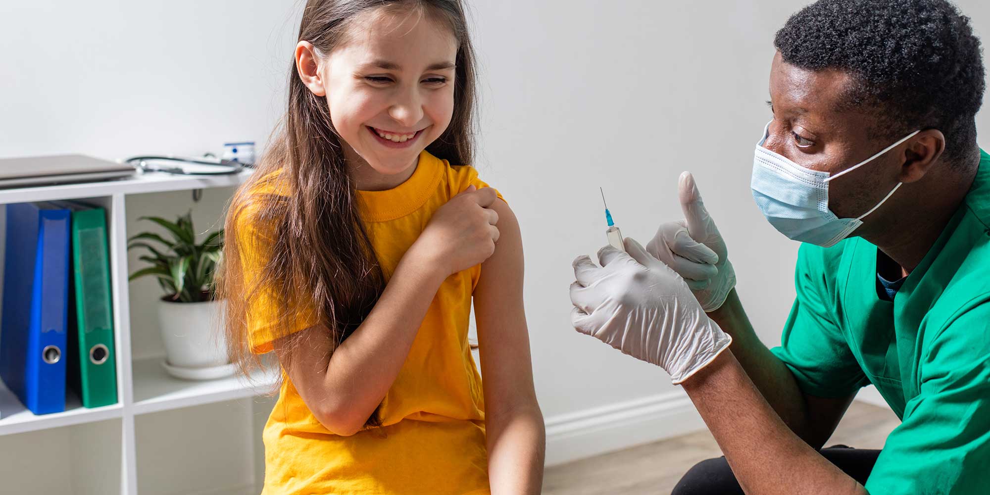 Smiling schoolgirl at the hospital for routine vaccination