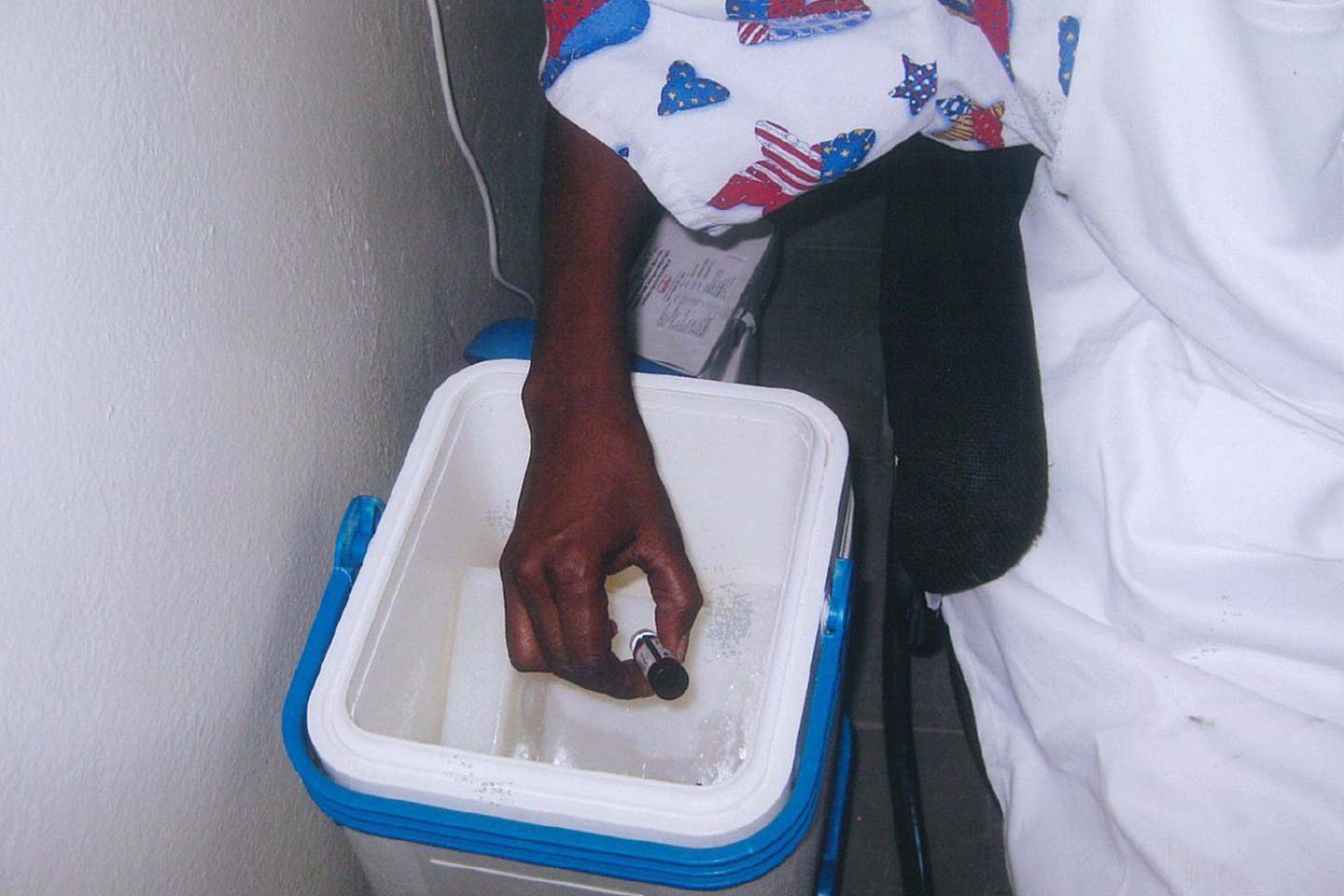 A health worker in Senegal pulls a vaccine vial out of a cold storage vaccine carrier. Ensuring that vaccines are kept at the right temperature is just one way that countries are preparing to immunize their populations against COVID-19. Photo: PATH.