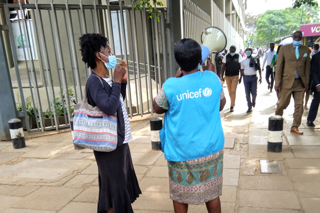 A Community health worker, Ms Elizabeth Oduor uses a loudspeaker to mobilise people to get COVID-19 jab at Nairobi's Kencom bus stage. Credit: Mike Mwaniki.