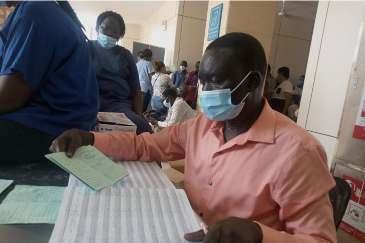 A healthcare worker at Juba Teaching Hospital crosschecks vaccination details in a card