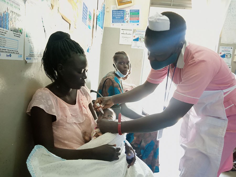 A vaccinator gives Oral Polio Vaccine to a baby at Munuki Health Center