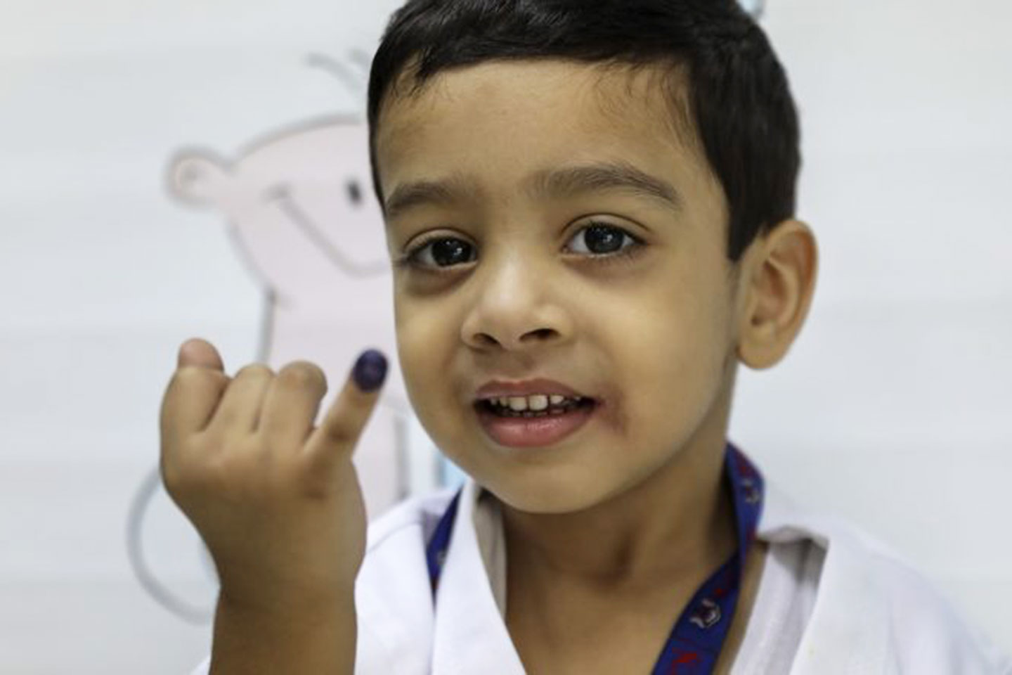 A boy proudly shows the ink mark on the tip of his finger. He was vaccinated against typhoid during the campaign in Sindh province in November 2019. PATH/Asad Zaidi