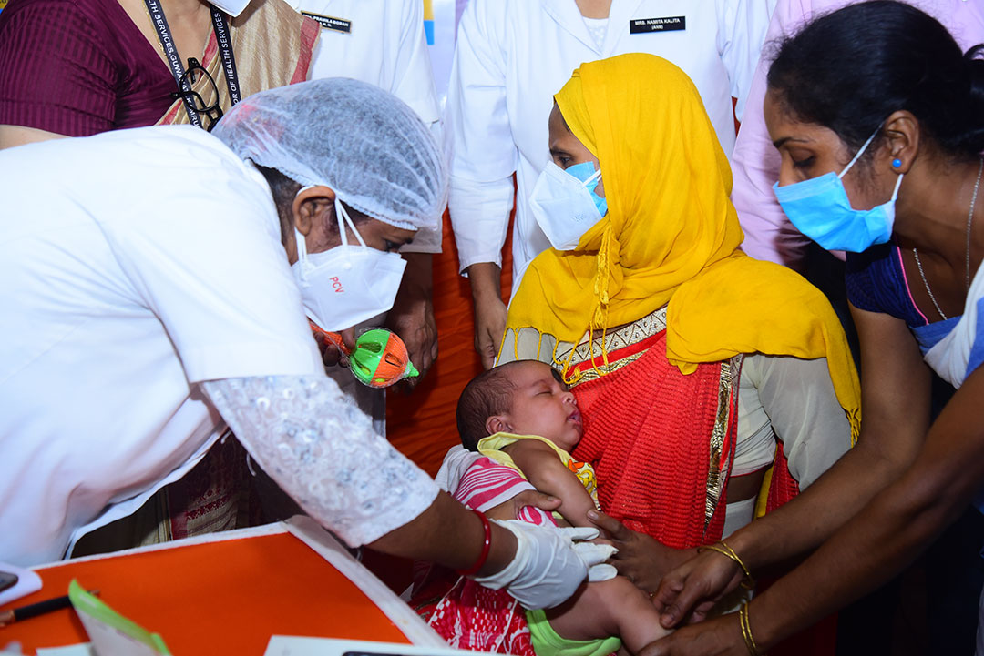 A mother takes her child to receive the PCV vaccine