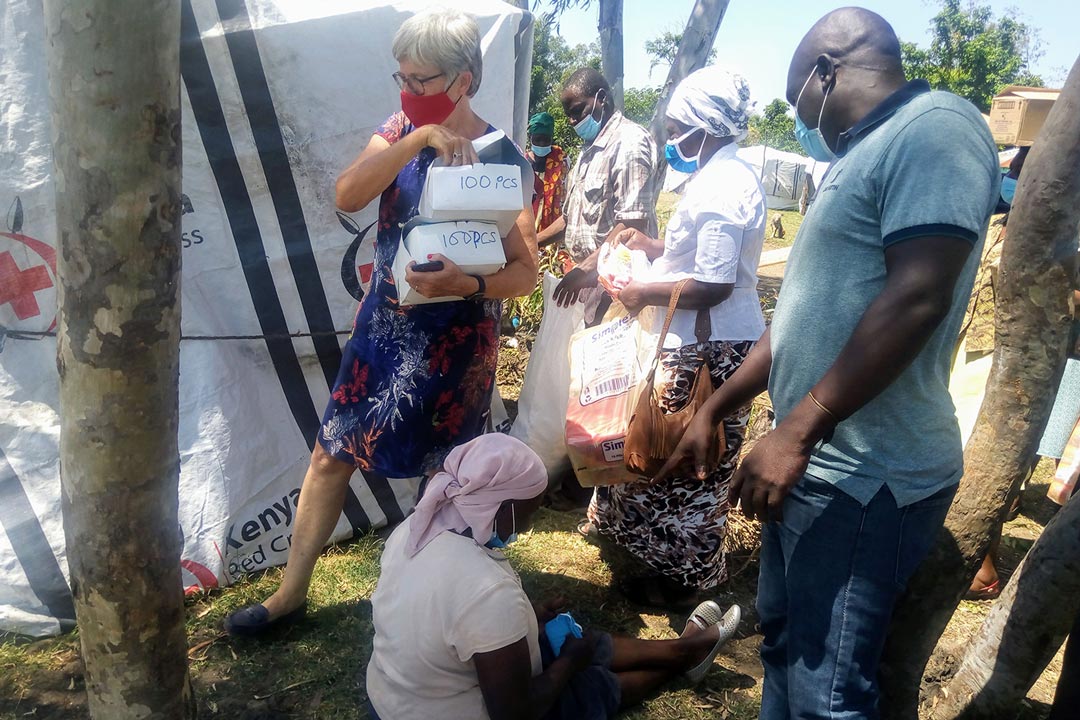 Safe Water and Aids Project (SWAP) founder Ali Eleveld (in a red mask ) distributes Covid-19 safety kits to Ombaka flood victims on June 8,2021 .Apart from supplying the victims with safety kits,the Non-government Organization through partnership with the Ministry of Health works on ensuring the vaccine is easily accessible to the victims in the camp .Photo Credit/Angeline Ochieng