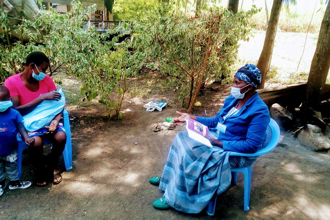 Ms Frandiscah Amolo educates Ms Emily Atieno on the importance of early childhood vaccinations and COVID-19 safety measures at her home in Holo, Kisumu County in Kenya on July 2, 2021. Photo credits /Angeline Ochieng