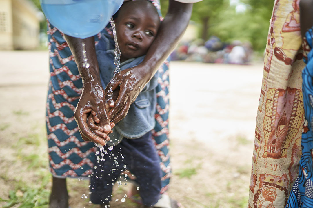 A woman in Marua washing her hands and the hands of her child – Photographer: Gavi/2020/Christophe Da Silva
