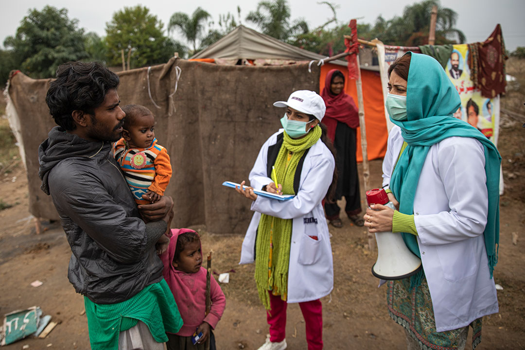 Sadaf Fareed, with her team talking to the man about the vaccination of his children. Credit: Gavi/2020/Asad Zaidi