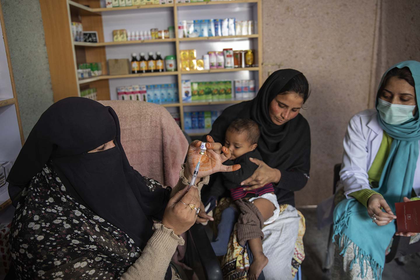 A female vaccinator, prepares pentavalent vaccine for Fakhra (zero-doze child) at the vaccination center in a slum in Islamabad. Credit: Credit: Gavi/2020/Asad Zaidi 
