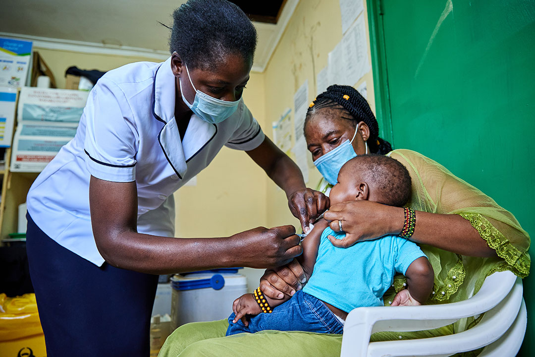 Nurse Janet Wanyama vaccinates 9-month-old Brilliant Hope against malaria while his mother Juliah Machanja watches at the Malava County Hospital Child Welfare Clinic in Kakamega, Kenya. Credit: Gavi/2021/White Rhino Films-Lameck Orina