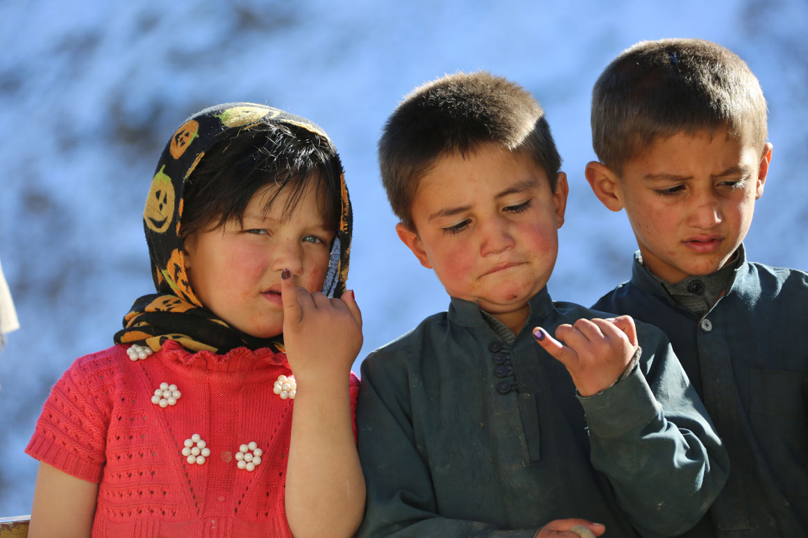 Twin brothers, Habib-u Rahman and Hamid-u Rahman, and their niece, show their inked fingers after being vaccinated against polio in Botawar village, Rukha district of Panjshir province. ©Ahmadullah Amarkhil/WHO Afghanistan
