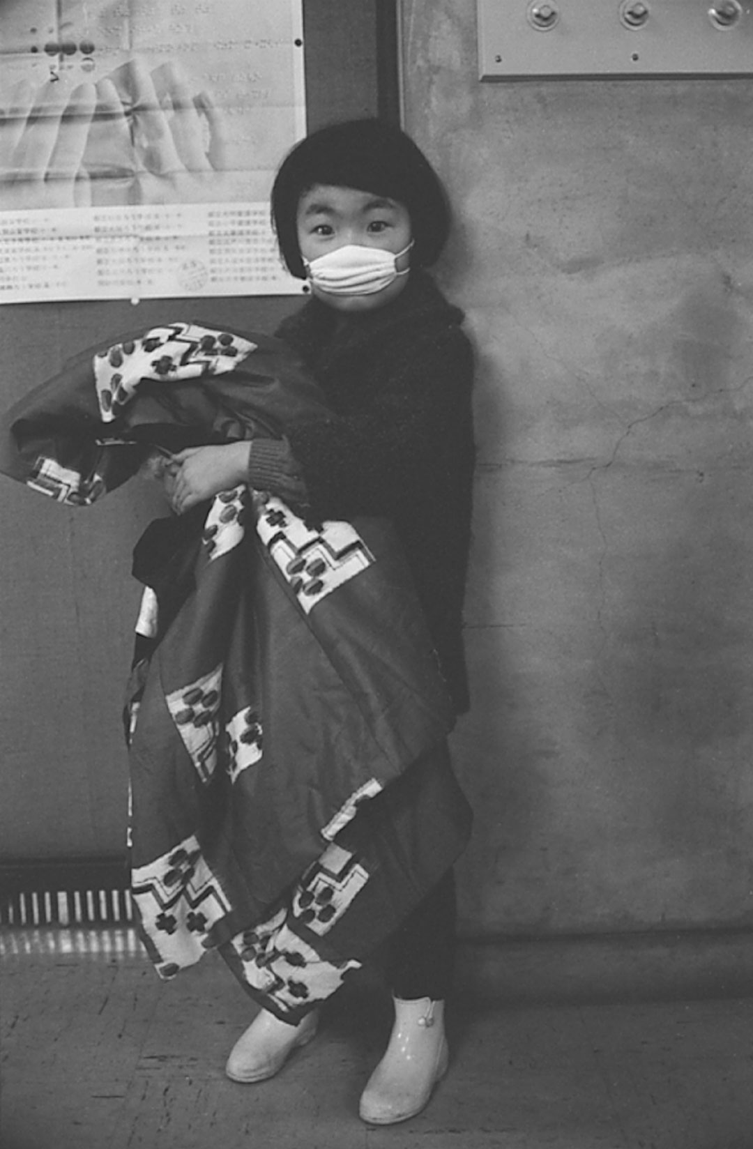 A child with a respiratory infection wearing a white mask in the streets of Tokyo.  Credit: WHO/Takeshi Takahara