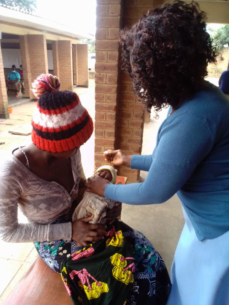 Zombazomba administers polio vaccine to a child Credit: Josephine Chinele