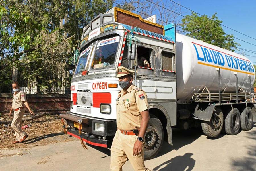 Police personnel escort a truck carrying medical liquid oxygen to the Guru Nanak Dev hospital in Amritsar, India, on April 24, 2021. Photo by NARINDER NANU/AFP via Getty Images
