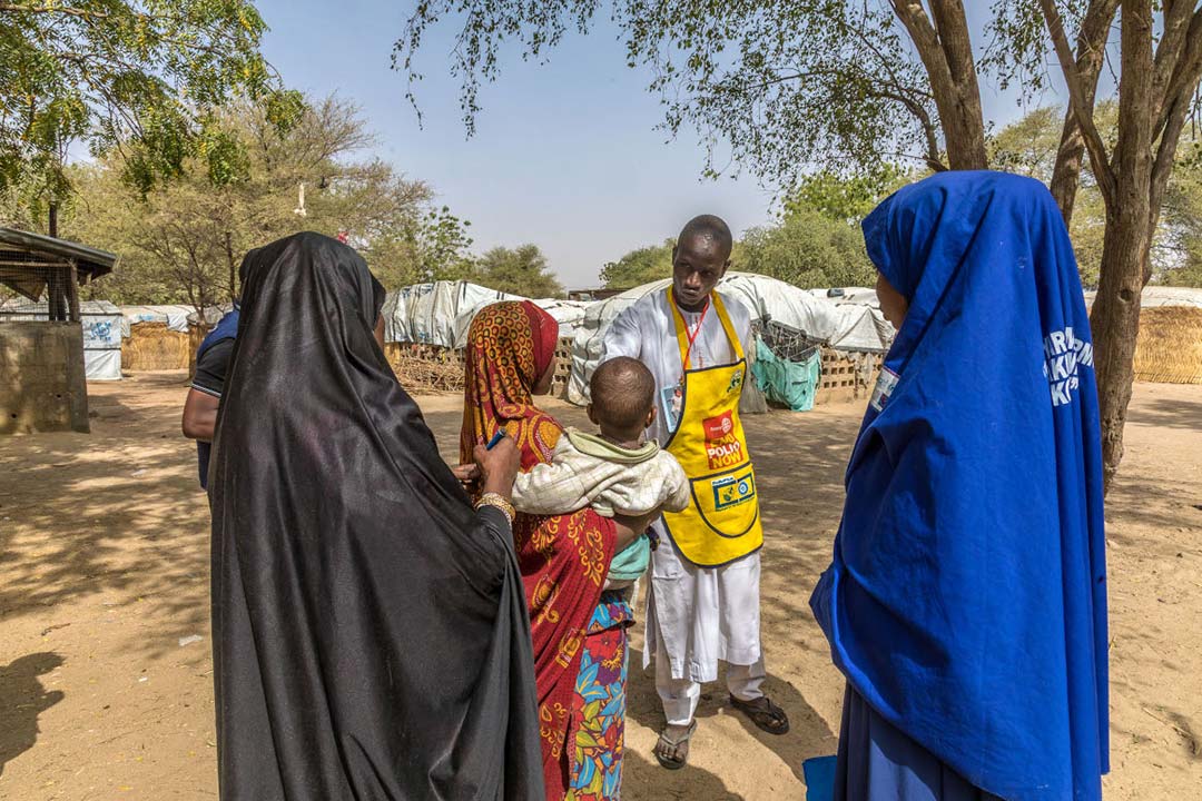 A polio worker speaks to a family in Borno State, Nigeria. In Nigeria, polio personnel have played a vital role to educate communities on COVID-19 and register individuals for their vaccination, underlining the necessity of sustaining these networks. © WHO/Andrew Esiebo