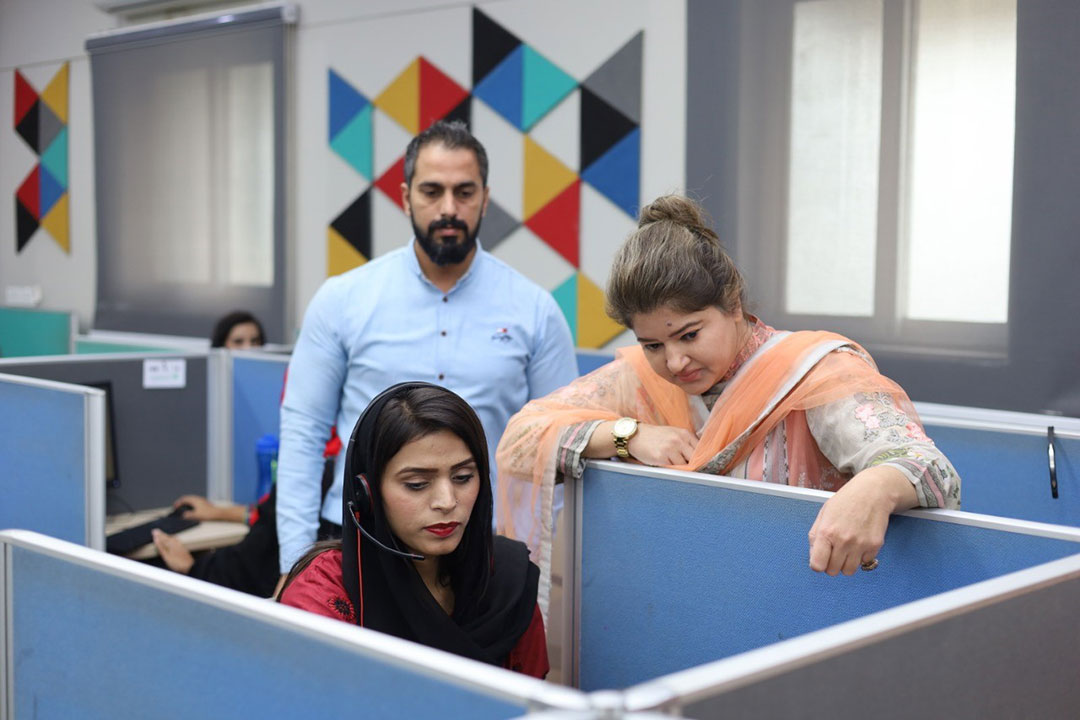 Huma Shaukat, call centre manager, consults with agent Faryal Tariq. Credit: Huma Khawar