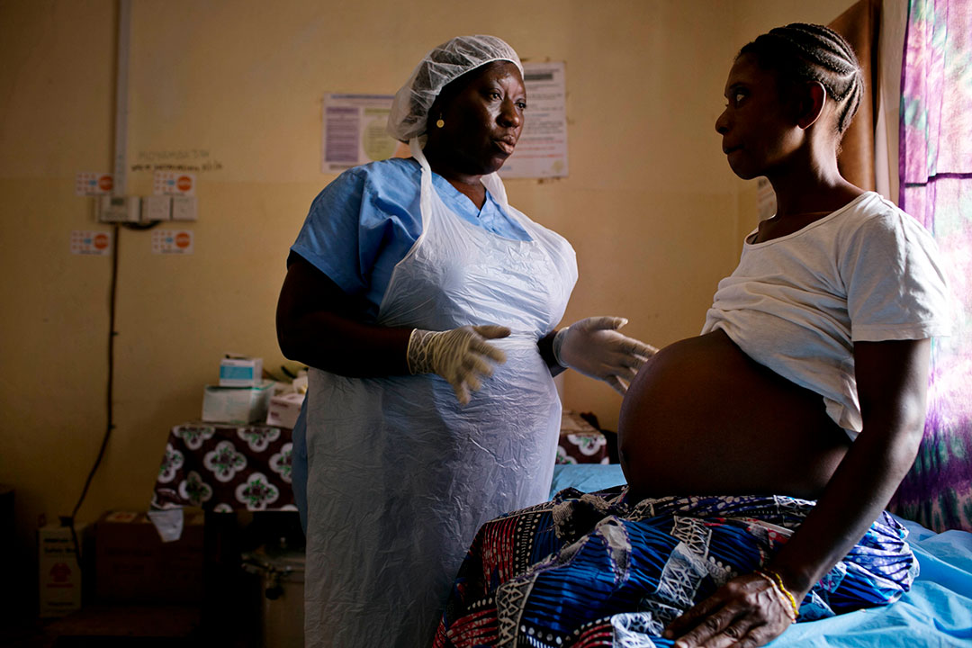 A midwife examines a pregnant woman at a health clinic. Gavi/2016/Kate Holt