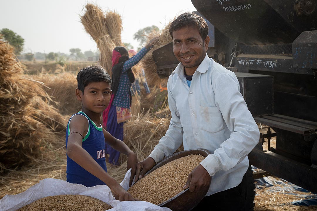 A boy and his Father filling a bag with grain. Rajasthan, India. Credit: Gavi/2021/Benedikt v.Loebell