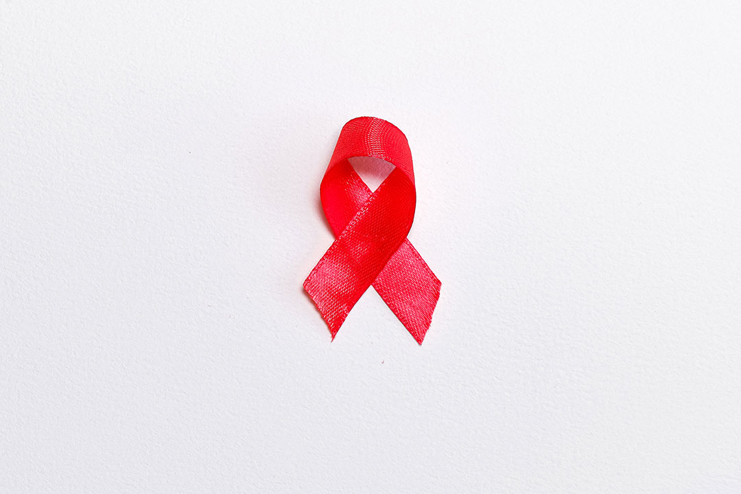 The red ribbon, the universal symbol of awareness and support for people living with HIV. Photo by Anna Shvets from Pexels