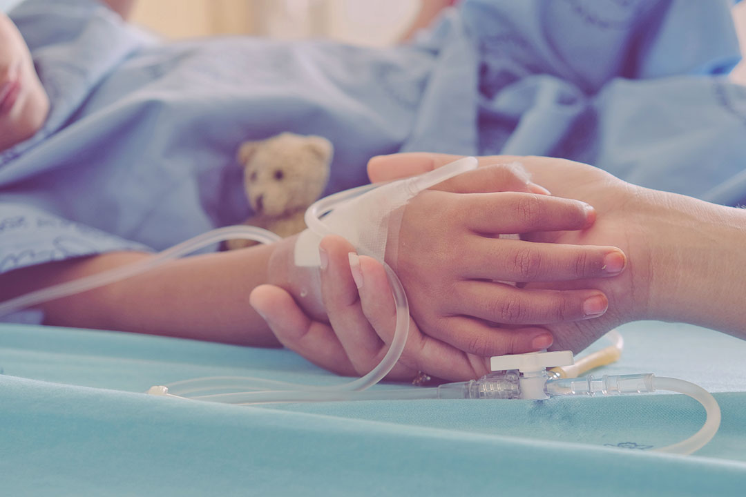 Mother holding child's hand who fever patients in hospital to give encouragement.