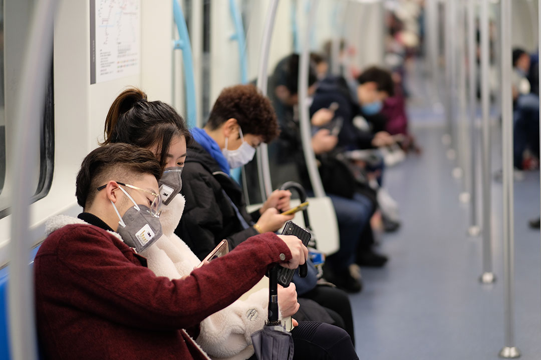 People wearing surgical mask sitting in subway