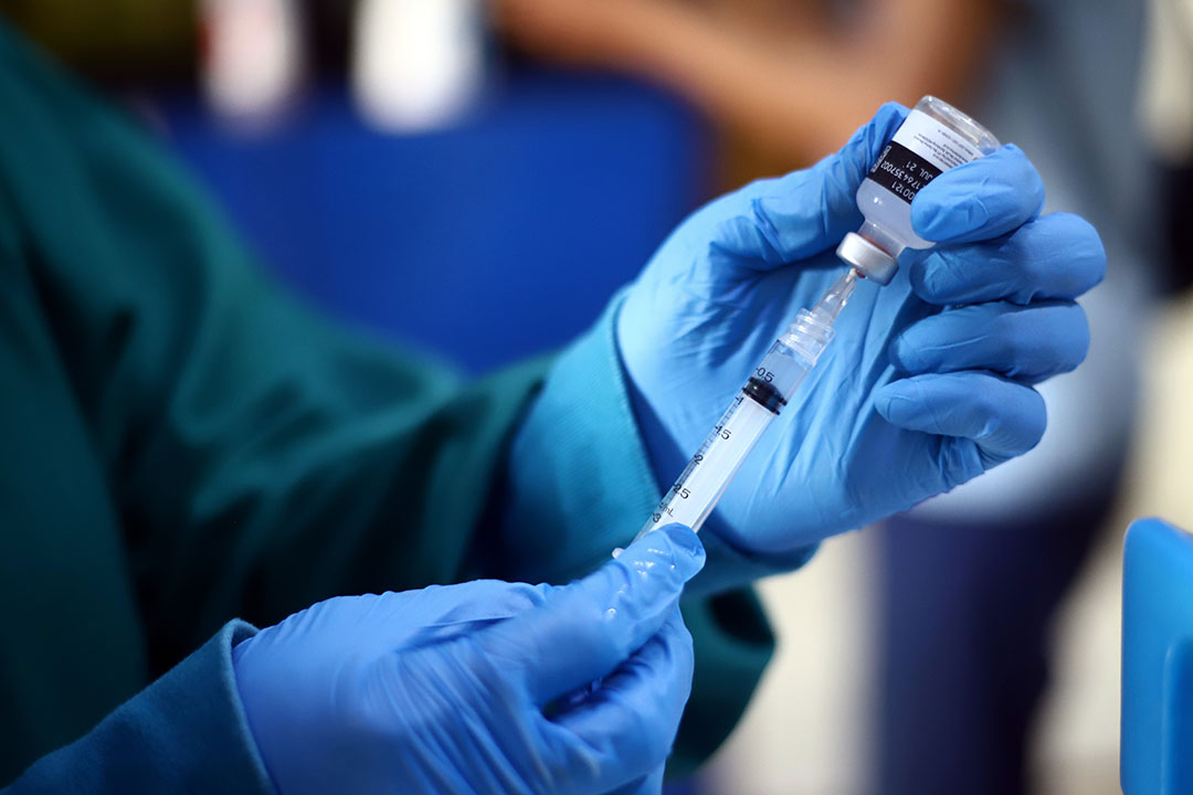 Health care practitioner preparing a COVID-19 vaccine.