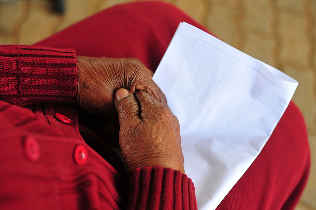 Close up shot of elderly hands on a vaccine registration.