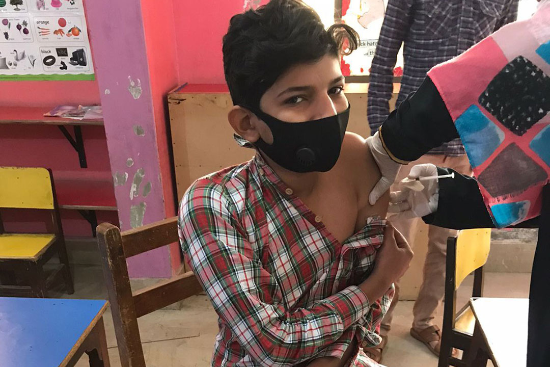 A student gets his second COVID-19 vaccination shot at Herald Citi School, Karachi. Photo: Saadeqa Khan