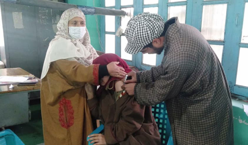 A young girl being vaccinated against COVID-19 in Madwan, Bandipora. Photo credits: Nasir Yousufi