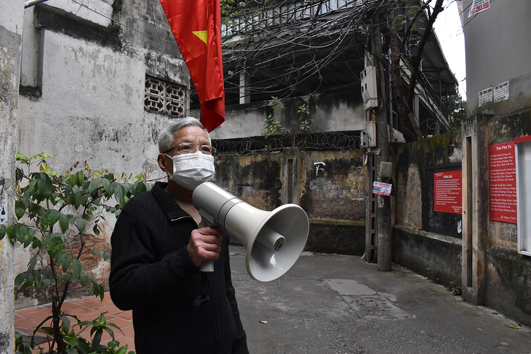 Mr Han Cong Khanh holds a loudspeaker in an alley of his neighbourhood in Hanoi, Vietnam.