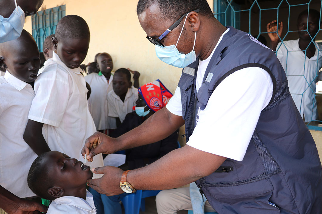 A health official vaccinating a child with cholera vaccine. Photo credit: WHO