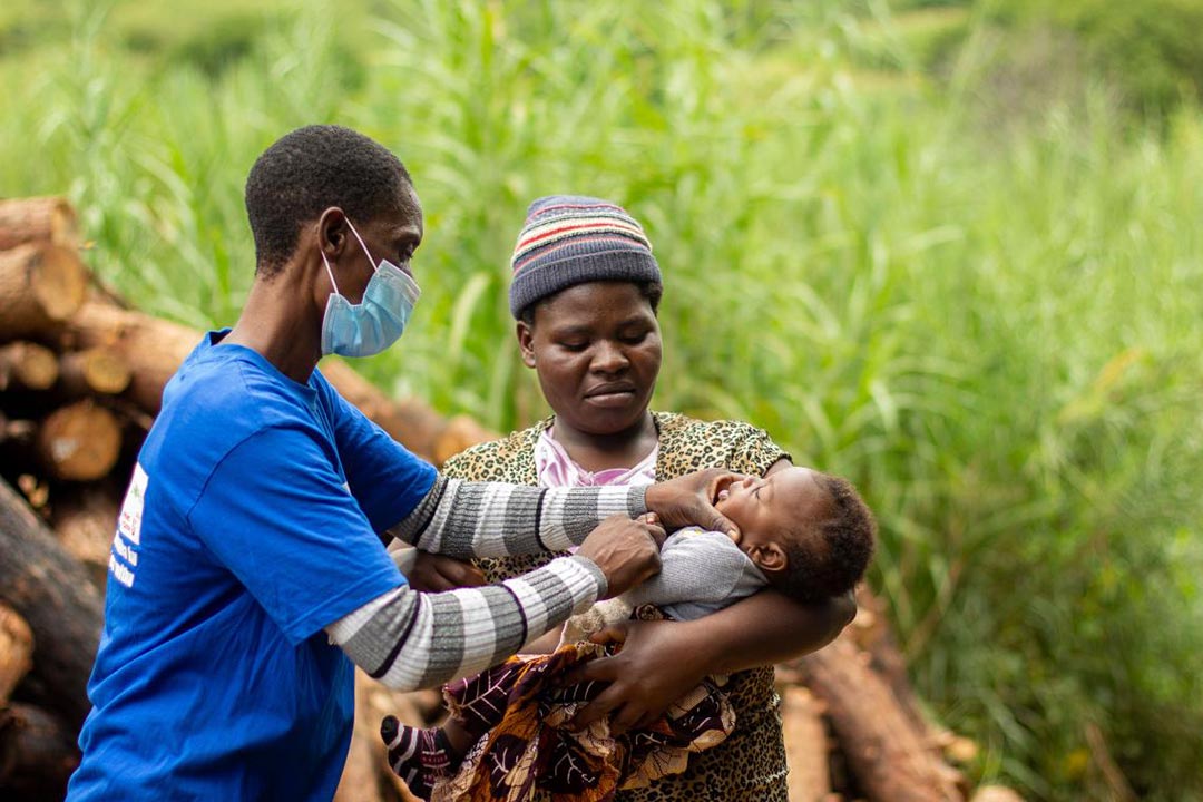 Mamie vaccinating three-month-old Vista with the polio vaccine. @ UNICEF Malawi/2022/HD Plus