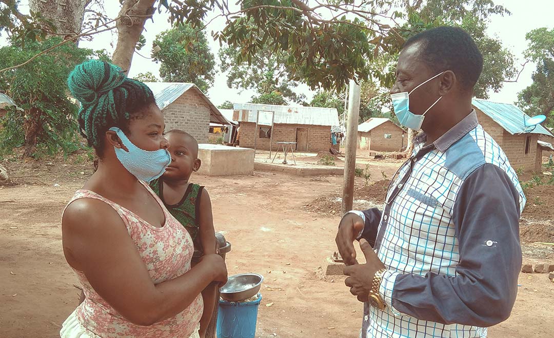 Laban helping dispel myths around COVID-19 with Mbia Juanet at the refugee settlement camp Ogoja. Photo Credit: Ijeoma Ukazu