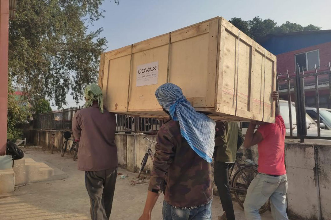 UNICEF Nepal/2021 – Workers carrying parts and accessories for the installation of the COVAX-supported walk-in cooler at the Provincial Health Logistics Management Centre in Dhangadhi, Sudurpaschim Province.