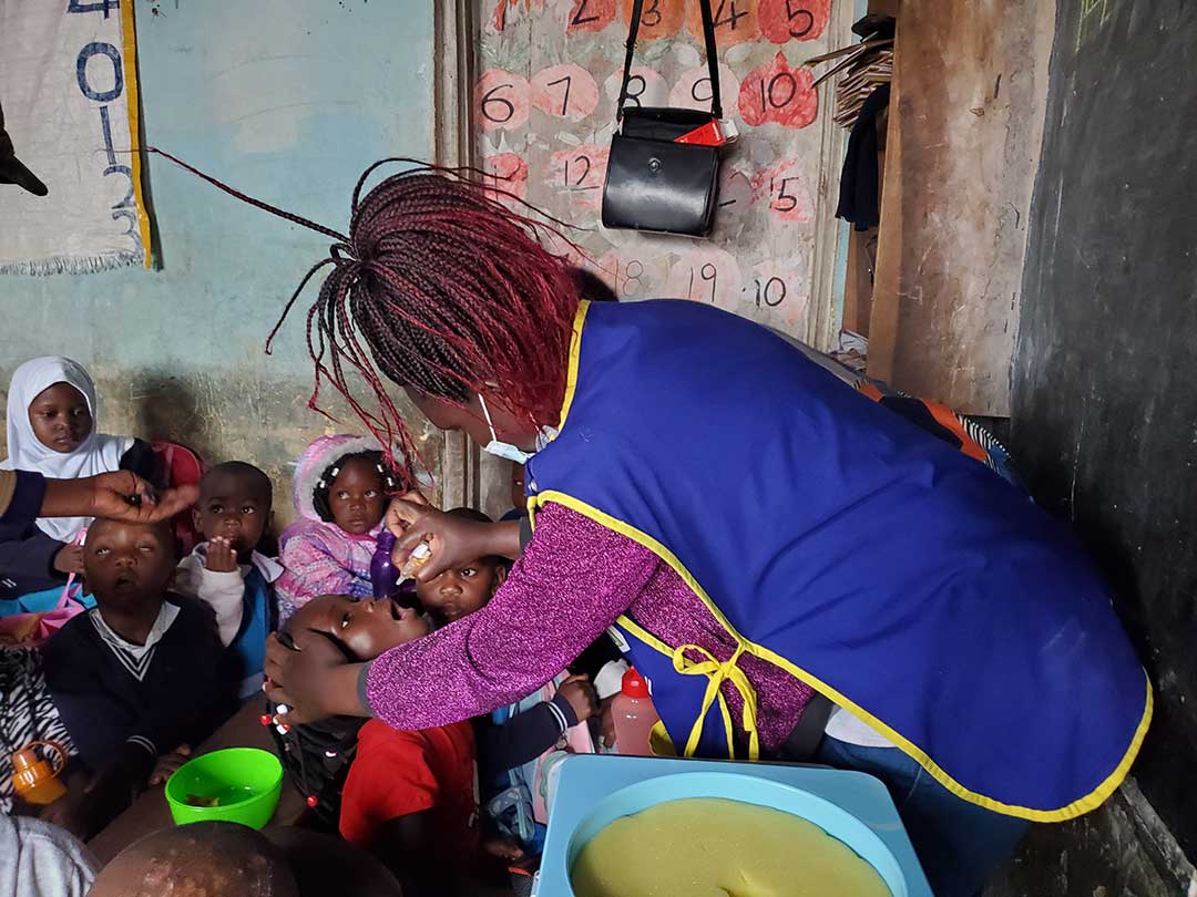 Juliet Acamango, a midwife at Kisugu Health Centre III administers the oral polio vaccine to a child at Umi Zaituni Nursery School in Kisugu, Kampala. The vaccination exercise is part of a nationwide door-to-door campaign targeting all children under the age of five.