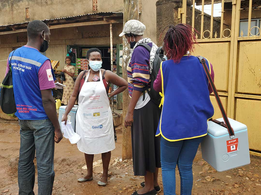 Health workers from Kisugu health Centre III and Village Health Team (VHT) volunteers in a discussion outside one of the informal neighborhoods in Namuwongo. They are part of a team of government health workers moving from door-to-door to vaccinate children against polio.