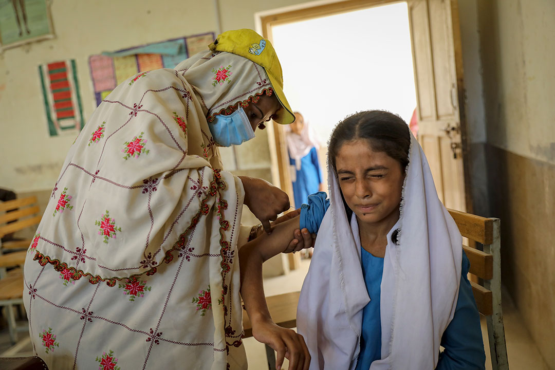 Anila, a lady health worker (LHW), administers a shot of TCV Sadiqa, aged ten, at the government girls’ middle school of Bagan Baba in Dera Allah Yar. Credit: Gavi/Asad Zaidi