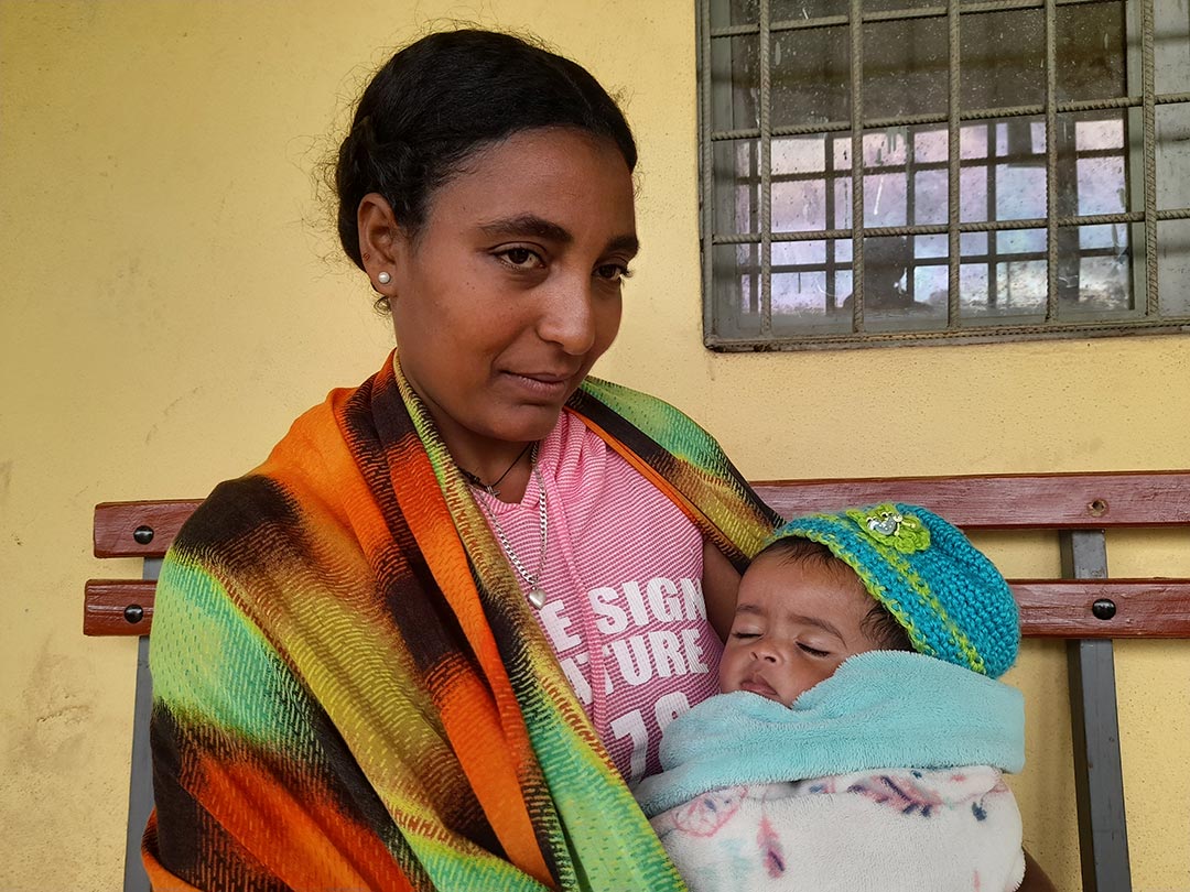 Sintayehu, caregiver at an orphanage, brings one of the children to get vaccinated. Credit: Solomon Yimer