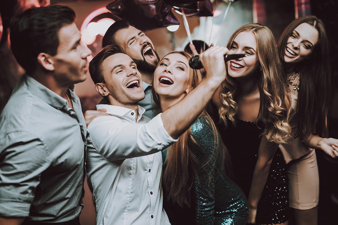 Young group of people singing into a mic.